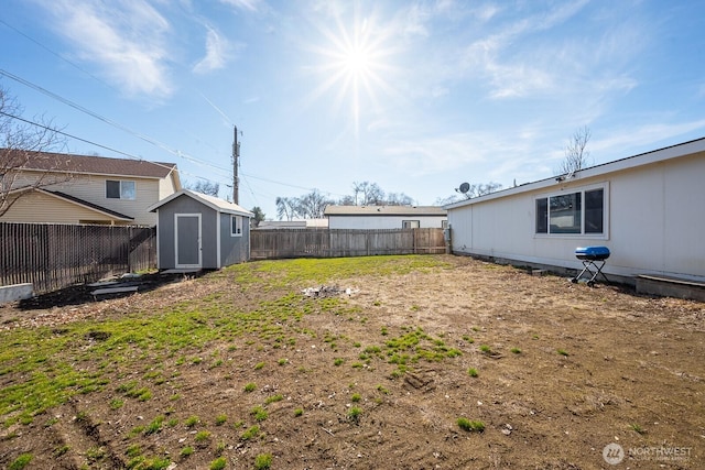 view of yard featuring a fenced backyard, a storage unit, and an outbuilding