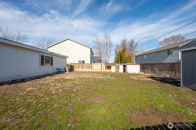 view of yard featuring an outbuilding, a fenced backyard, and a shed