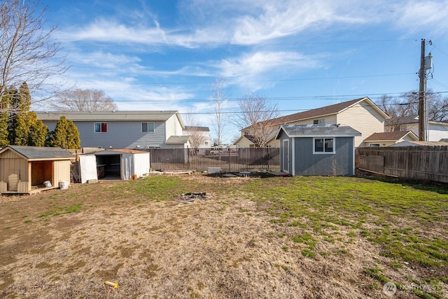 view of yard with a storage shed, an outbuilding, and a fenced backyard