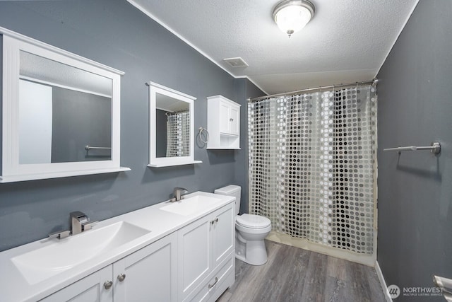 full bath featuring a sink, a textured ceiling, toilet, and wood finished floors