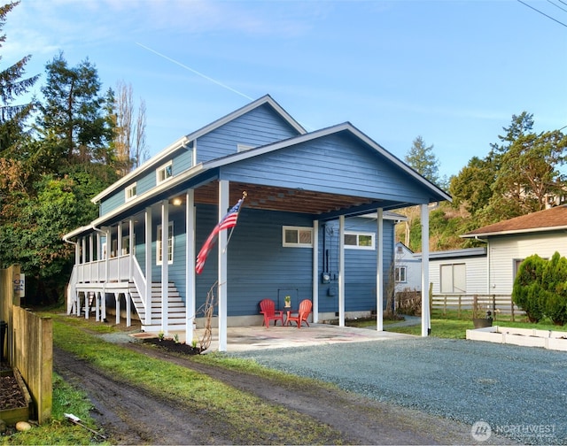 view of front of house featuring driveway, fence, and an attached carport