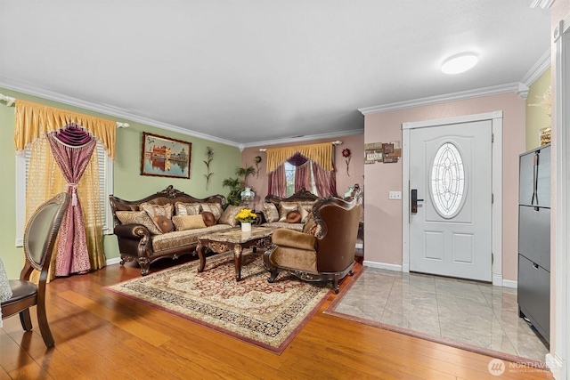 living room featuring baseboards, hardwood / wood-style flooring, and crown molding