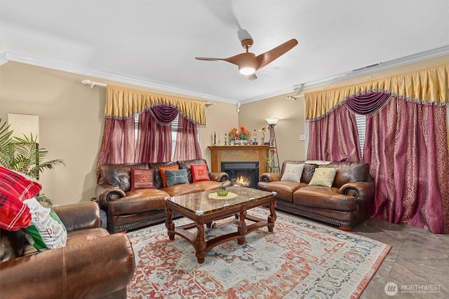 living room with ornamental molding, a lit fireplace, and a ceiling fan