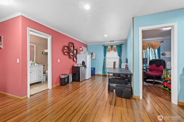 office area featuring ornamental molding, light wood-style flooring, and baseboards