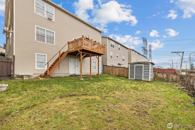 rear view of house featuring a fenced backyard, a lawn, and an outbuilding