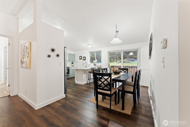 dining space with dark wood-style flooring and baseboards