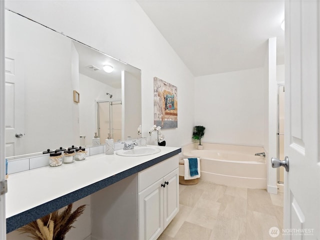 full bathroom with visible vents, a stall shower, vaulted ceiling, vanity, and a bath