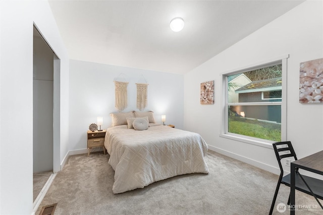 bedroom with light colored carpet, visible vents, vaulted ceiling, and baseboards