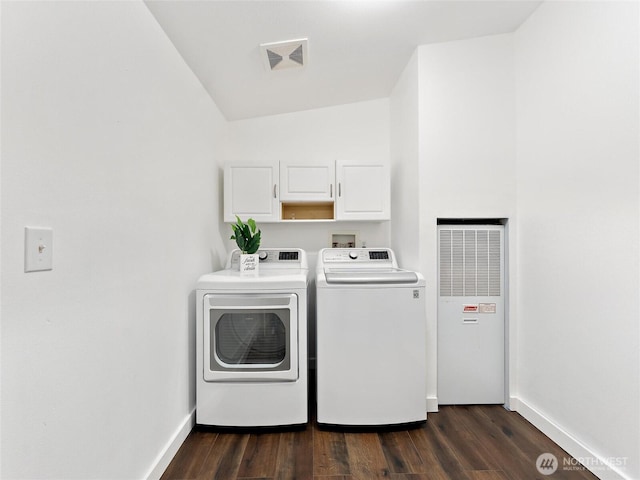 washroom with cabinet space, washing machine and dryer, baseboards, and dark wood finished floors