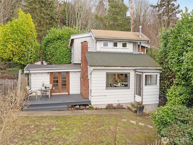 rear view of property featuring entry steps, a shingled roof, french doors, and a wooden deck