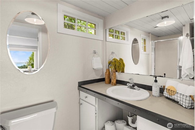 bathroom with a stall shower, wooden ceiling, vanity, and toilet