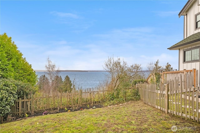 view of yard featuring a water view and fence