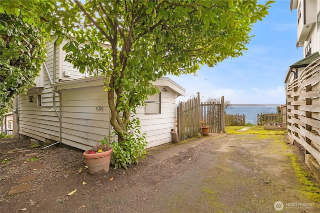 view of side of property with a water view and fence