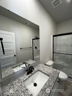 bathroom featuring toilet, visible vents, a stall shower, and vanity