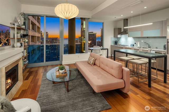 living area with recessed lighting, a view of city, wood finished floors, and a tile fireplace