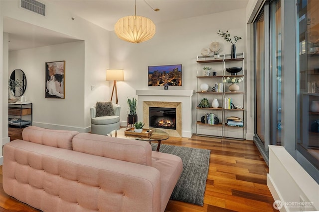 living room with light wood-style floors, baseboards, a fireplace, and visible vents