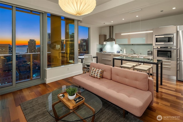 living room with a view of city, a water view, and wood finished floors