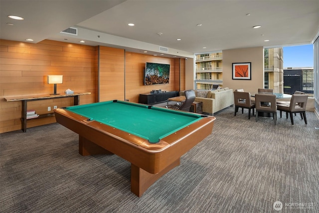 recreation room featuring dark colored carpet, visible vents, wood walls, and recessed lighting