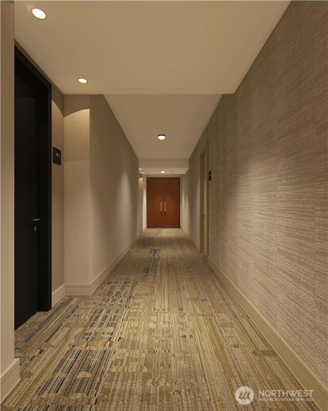 corridor featuring wallpapered walls, an accent wall, baseboards, and recessed lighting