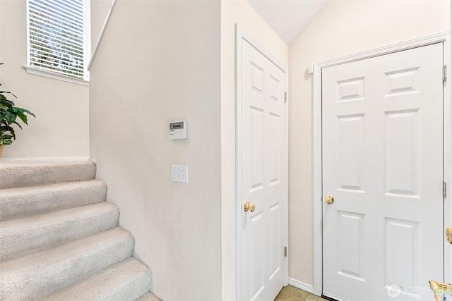 stairway featuring vaulted ceiling