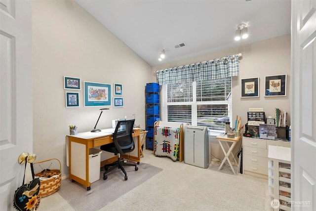 office area featuring lofted ceiling, light carpet, and visible vents