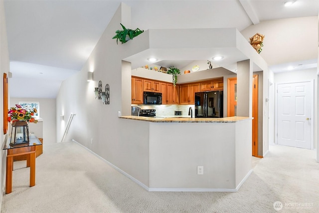 kitchen featuring brown cabinets, lofted ceiling, light colored carpet, a peninsula, and black appliances