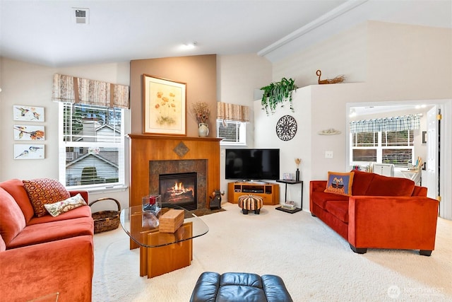 carpeted living room featuring a fireplace with flush hearth, visible vents, and vaulted ceiling