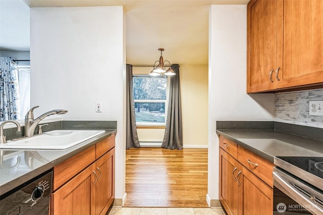 kitchen featuring dark countertops, black dishwasher, brown cabinets, and a sink