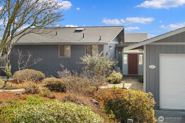 view of front of home with a garage and a shingled roof