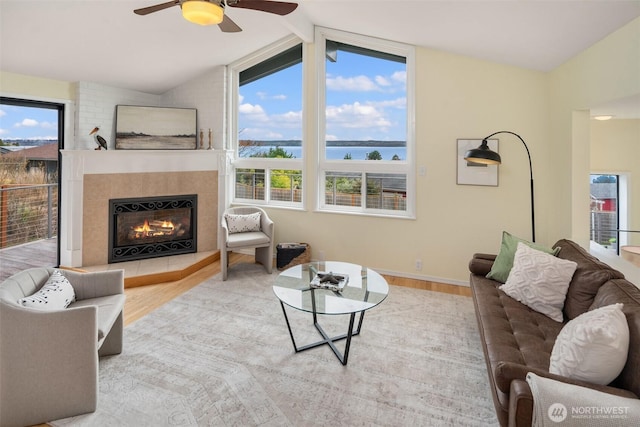 living room with vaulted ceiling with beams, a healthy amount of sunlight, wood finished floors, and a fireplace