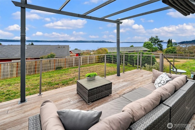 wooden deck with an outdoor living space, a fenced backyard, and a water view