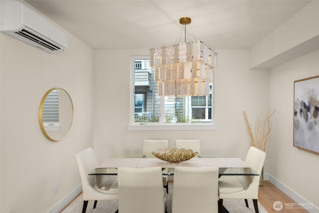 dining room featuring wood finished floors, baseboards, and a wall mounted AC