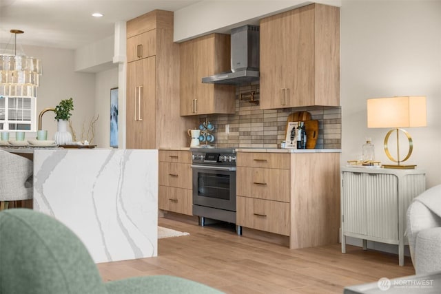 kitchen with wall chimney exhaust hood, stainless steel range, and modern cabinets