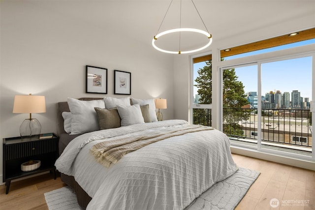 bedroom with light wood finished floors and a city view