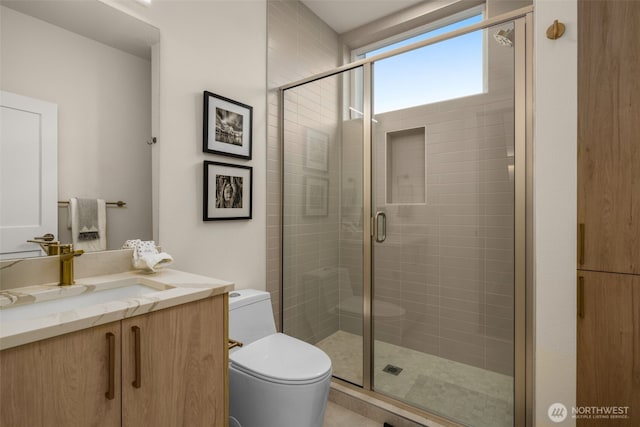 full bathroom featuring toilet, a stall shower, and vanity