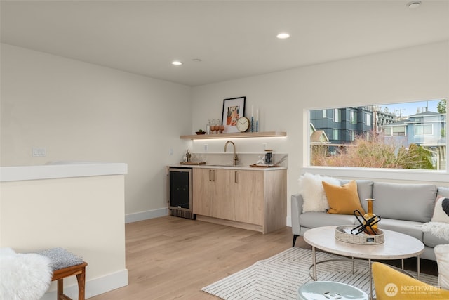 living area with light wood-type flooring, wine cooler, indoor wet bar, and recessed lighting