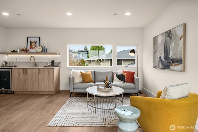 living room with light wood-type flooring, beverage cooler, wet bar, and recessed lighting