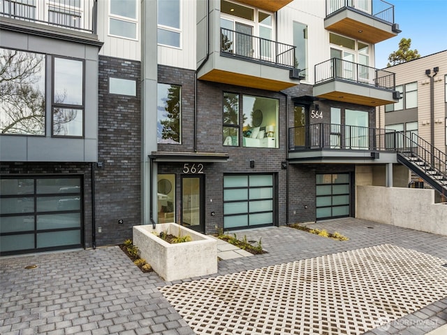 view of front of property with decorative driveway and brick siding