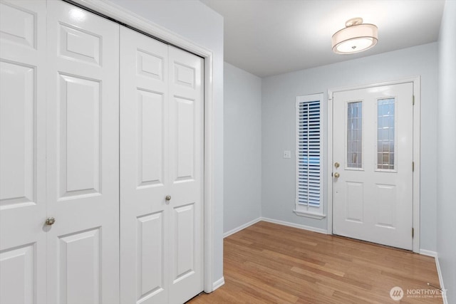 foyer featuring baseboards and light wood-style floors