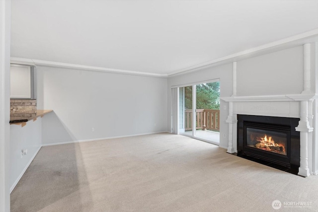 unfurnished living room with a fireplace with flush hearth, baseboards, and carpet floors