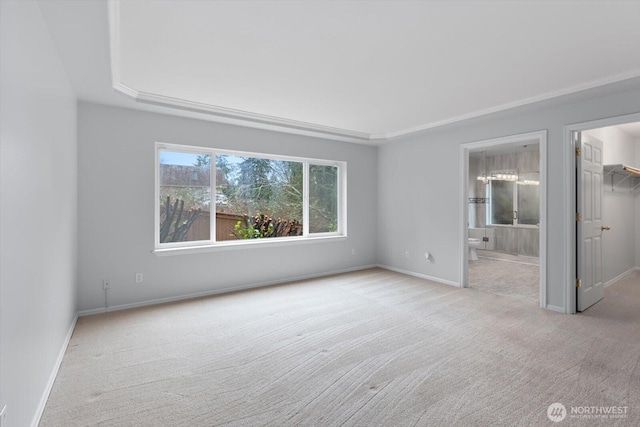 unfurnished bedroom with baseboards, a closet, ensuite bathroom, a walk in closet, and carpet flooring