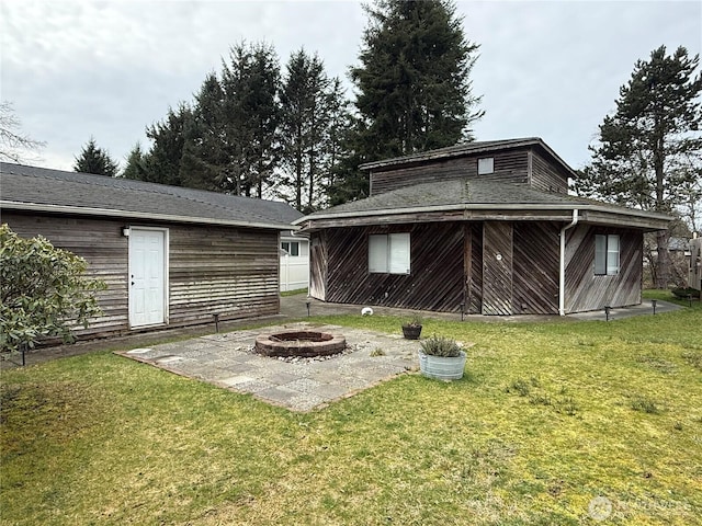 back of property with a yard, an outdoor fire pit, and a patio