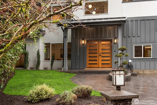 doorway to property featuring a lawn and board and batten siding