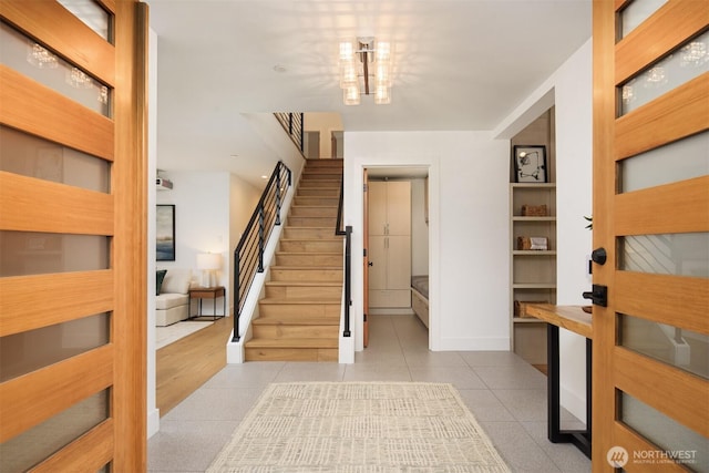 foyer with stairs, baseboards, and tile patterned floors