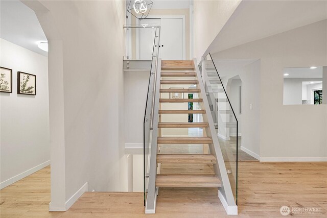 stairs with baseboards and wood finished floors