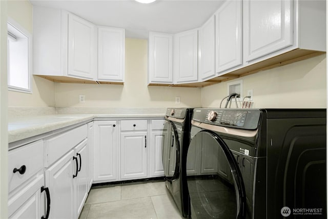 washroom featuring separate washer and dryer, light tile patterned flooring, and cabinet space