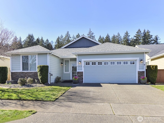 view of front facade with a garage, a shingled roof, stone siding, concrete driveway, and a front lawn