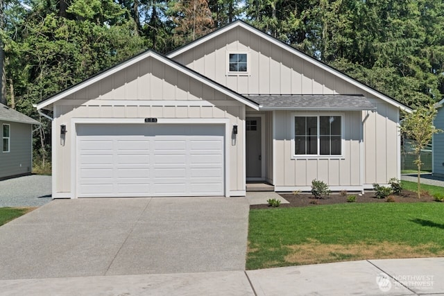 view of front of house with a garage, driveway, a shingled roof, board and batten siding, and a front yard