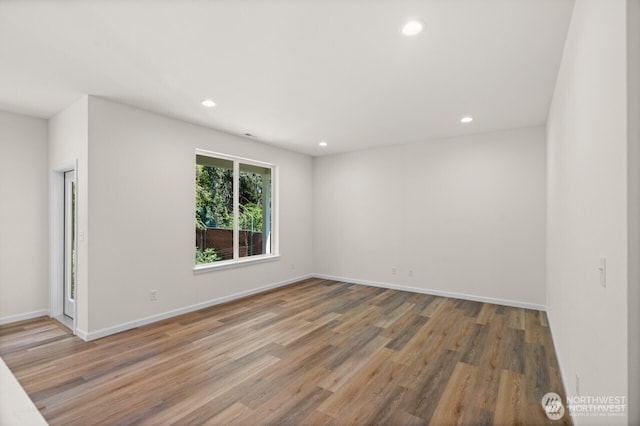 spare room featuring recessed lighting, baseboards, and wood finished floors