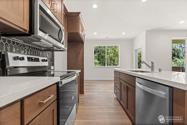 kitchen featuring light countertops, appliances with stainless steel finishes, a sink, and recessed lighting